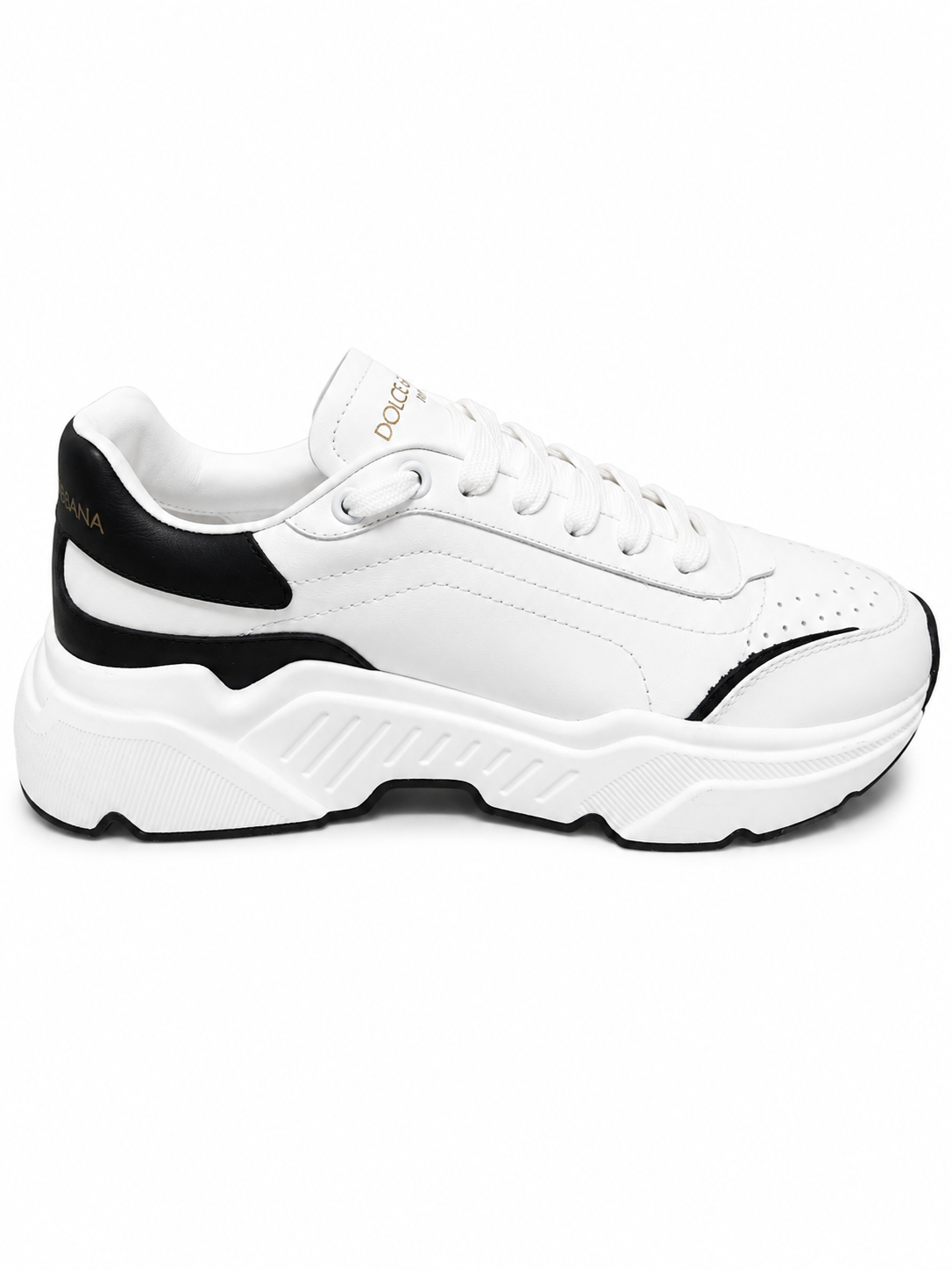A white chunky platform sneaker with black accents on the heel, side, and outsole, featuring the brand name 'DOLCE vita' printed in gold on the tongue.