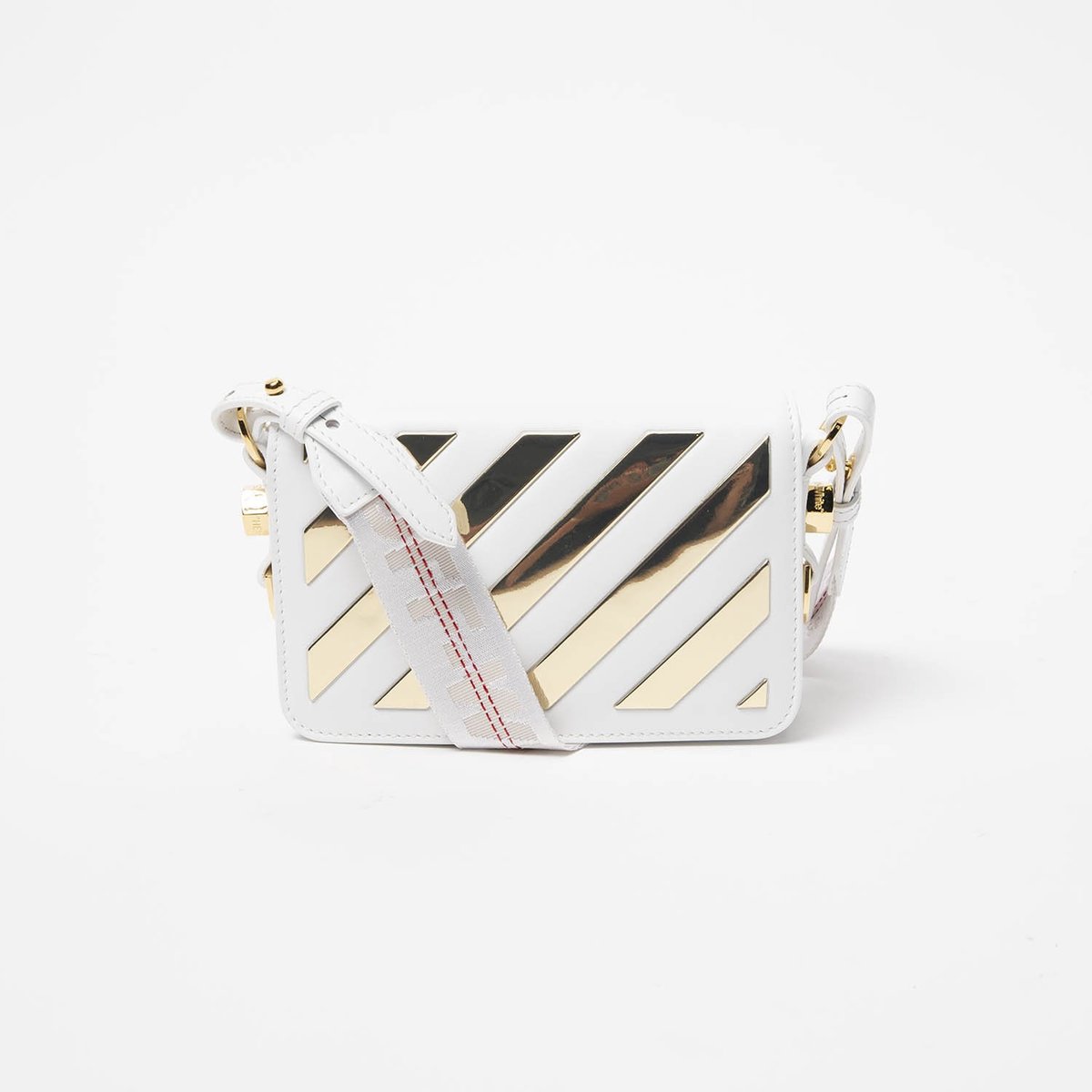 A white faux-leather shoulder bag with diagonal metallic gold and black chevron stripes, featuring a white leather strap with red stitching and gold hardware, set against a plain white background.