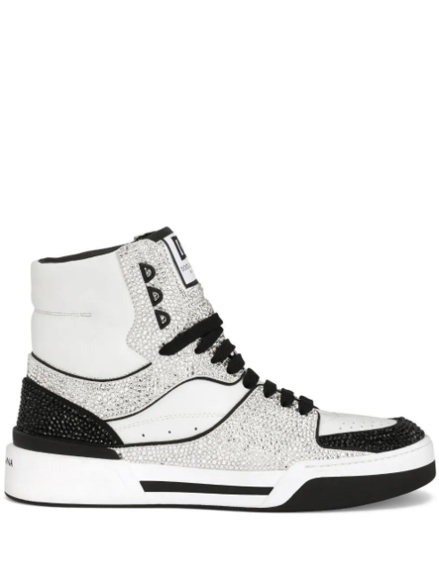 A high-top sneaker featuring a white leather base heavily embellished with silver rhinestones, accented with black details including the laces, toe cap, and heel section, set against a plain white background.