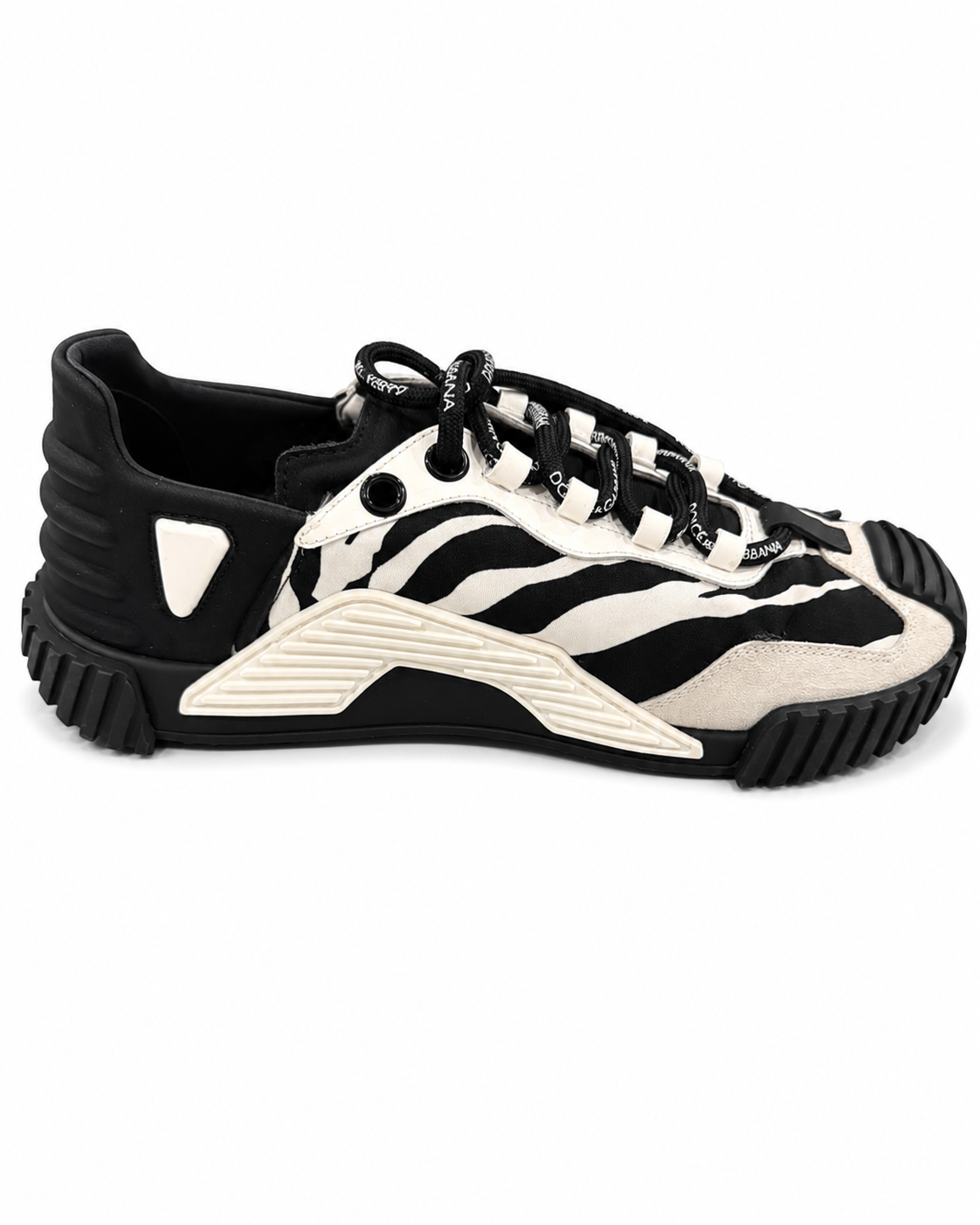 A black and off-white zebra-print sneaker with a chunky, sculpted sole and black laces, shown from a side profile on a white background.