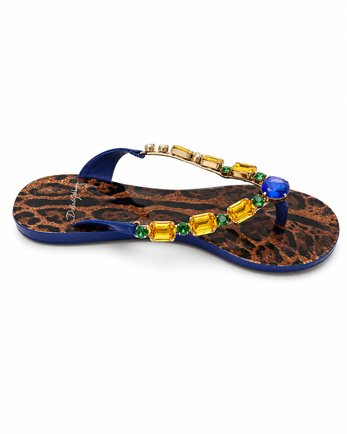 A single embellished thong sandal with a blue strap and footbed, featuring a brown leopard print base decorated with yellow and green gemstone accents and a large blue crystal on the toe post.